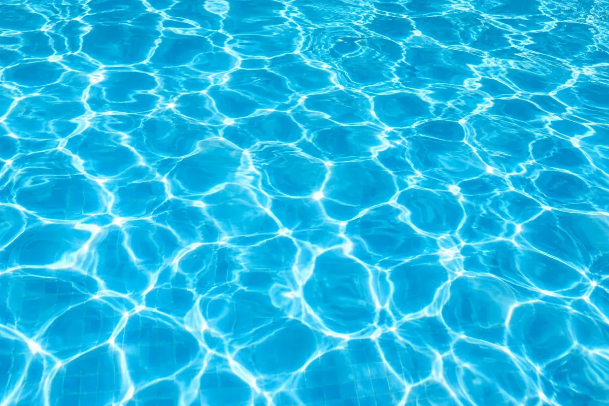 Sunlight rippling across clear blue pool water